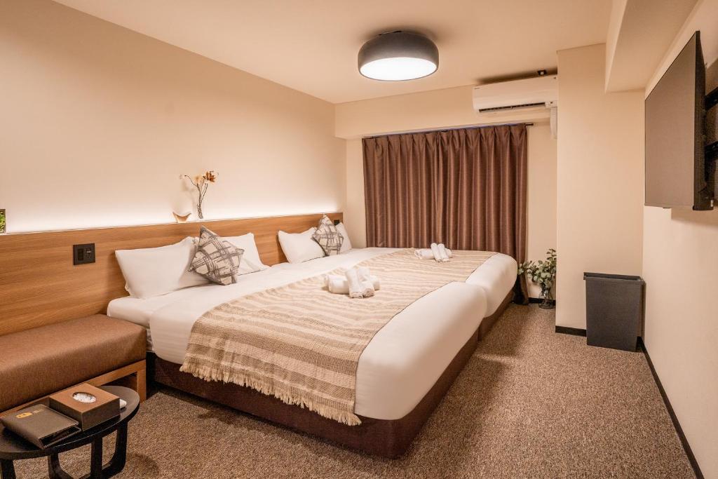 Una habitación de hotel con una cama con dos animales de peluche. en Lite House Shinsaibashi 4, en Osaka
