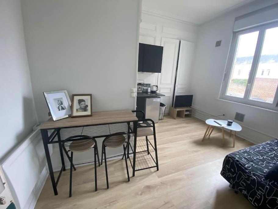 un salon avec une table et des chaises dans une pièce dans l'établissement Le mimosa T, à Amiens