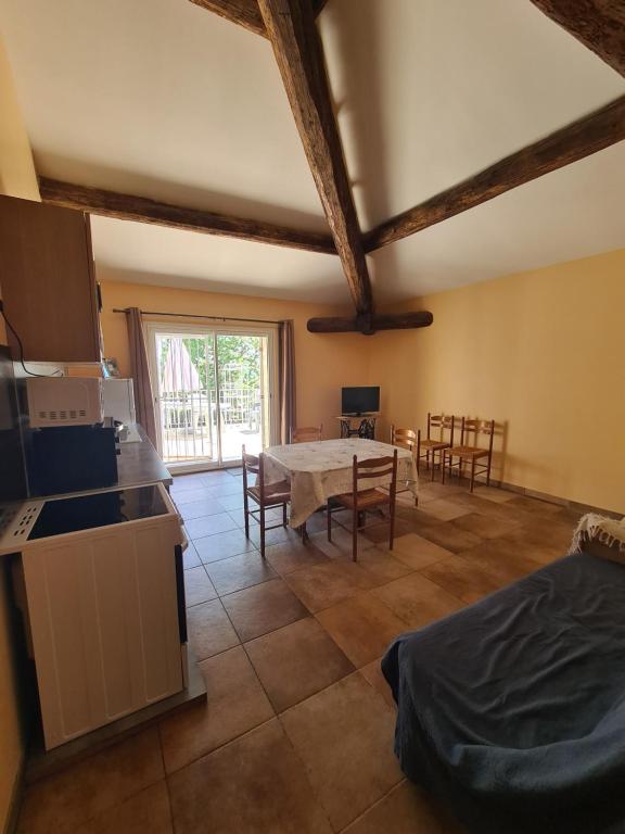 Una cocina y una sala de estar con mesa y sillas. en Hameau De Cure, en Cazouls-lès-Béziers