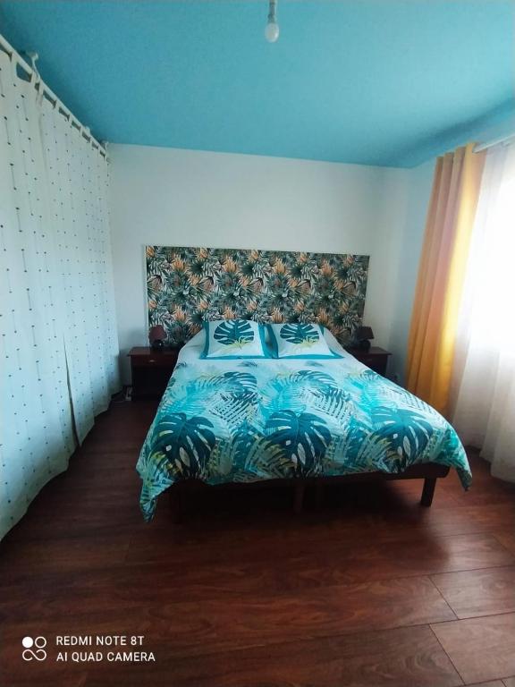 una camera da letto con un letto con un piumone blu di Ti'Commerson a Maison de lʼEnfance