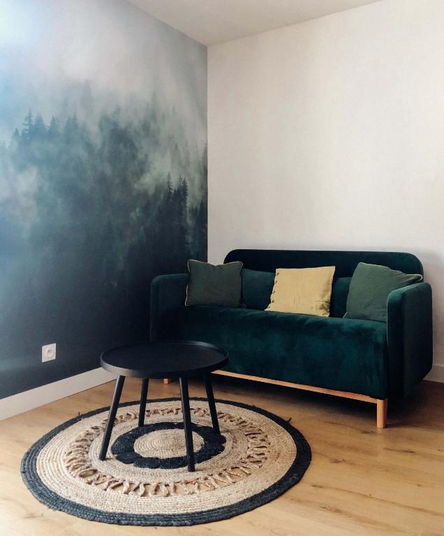 - un salon avec un canapé vert et un tabouret dans l'établissement Cano'Py, charmant 2 pièces avec vue montagne en cœur de ville, à Luchon