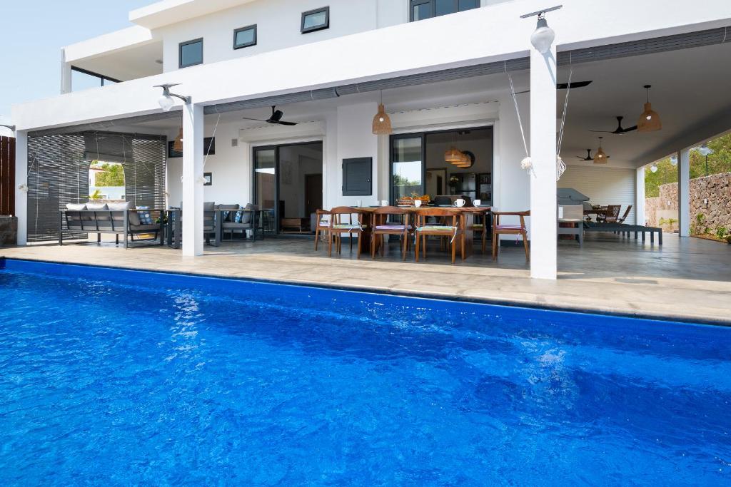 a house with a swimming pool in front of a house at Villa SERENITY neuve,4 chambres, 5 min de la plage in Calodyne