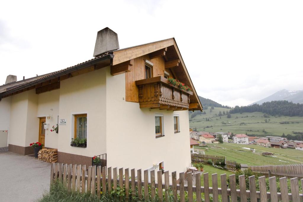 een klein huis met een balkon en een hek bij Haus Prieth in Nauders