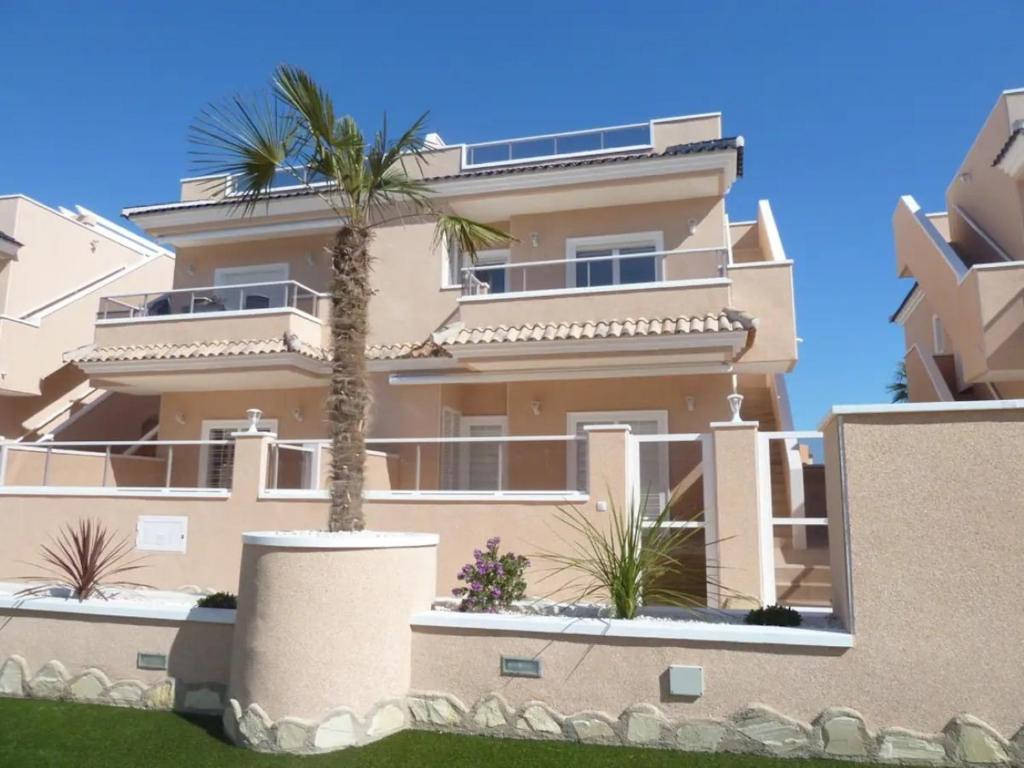 un bâtiment avec un palmier devant dans l'établissement Vista Azul Spa Resort, à Punta Prima