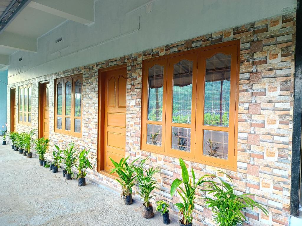 a brick building with a row of windows and potted plants at Travelmate Vagamon in Vagamon