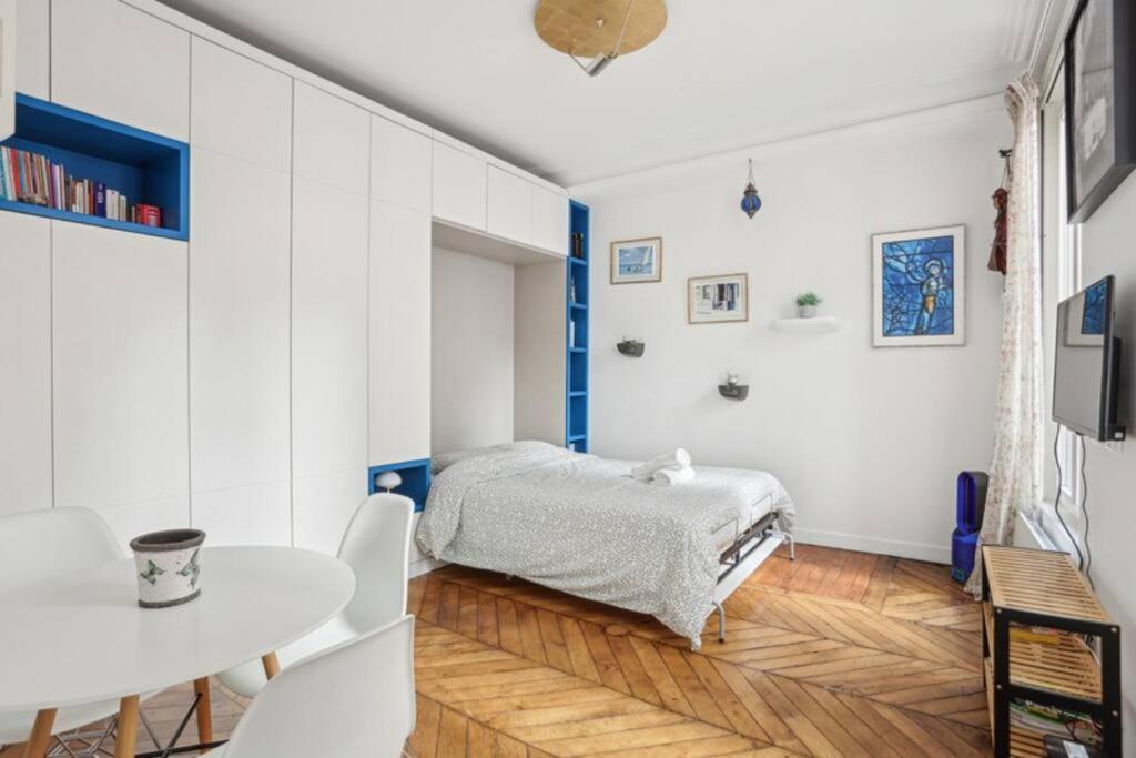 une chambre avec un lit, une table et des chaises dans l'établissement DesignAppart - Île Saint-Louis, Notre-Dame, Marais, à Paris