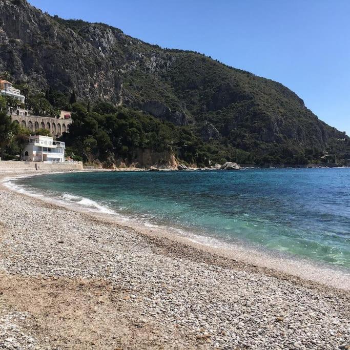 une plage avec une rive rocheuse et une montagne dans l'établissement Maison bord de mer Eze, à Èze