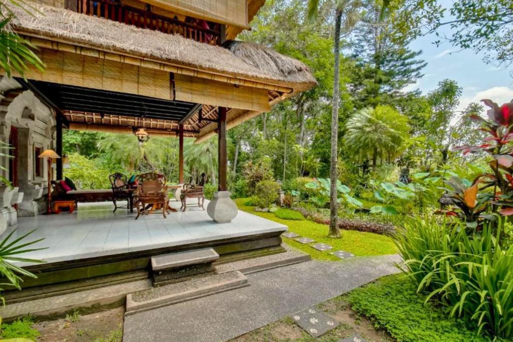 a pavilion with a table and chairs in a garden at Isvara 1 BR Junior Suite ZN235 in Ubud