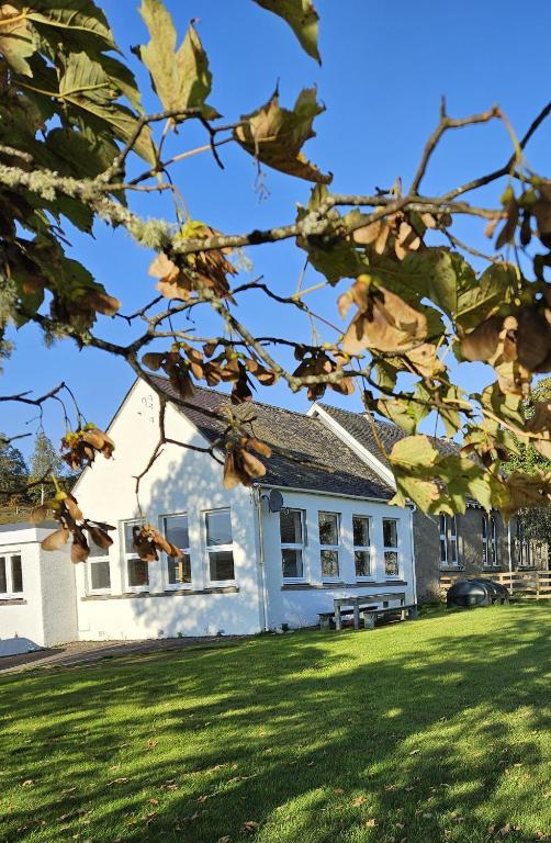 a white house with a bench in front of it at Old School, Spean Bridge - fun, friendly, relaxed in Spean Bridge