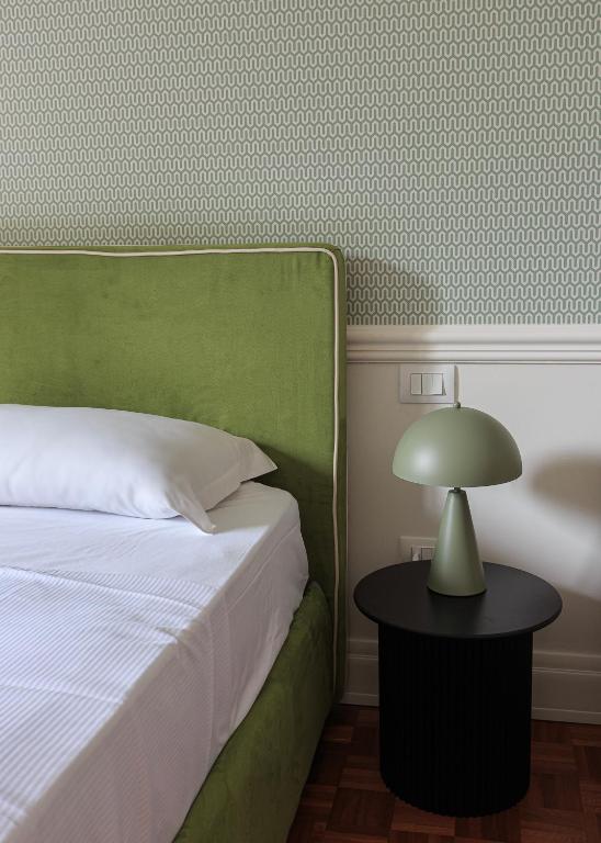 a bedroom with a bed and a table with a lamp at Gramsci Baveno in Baveno