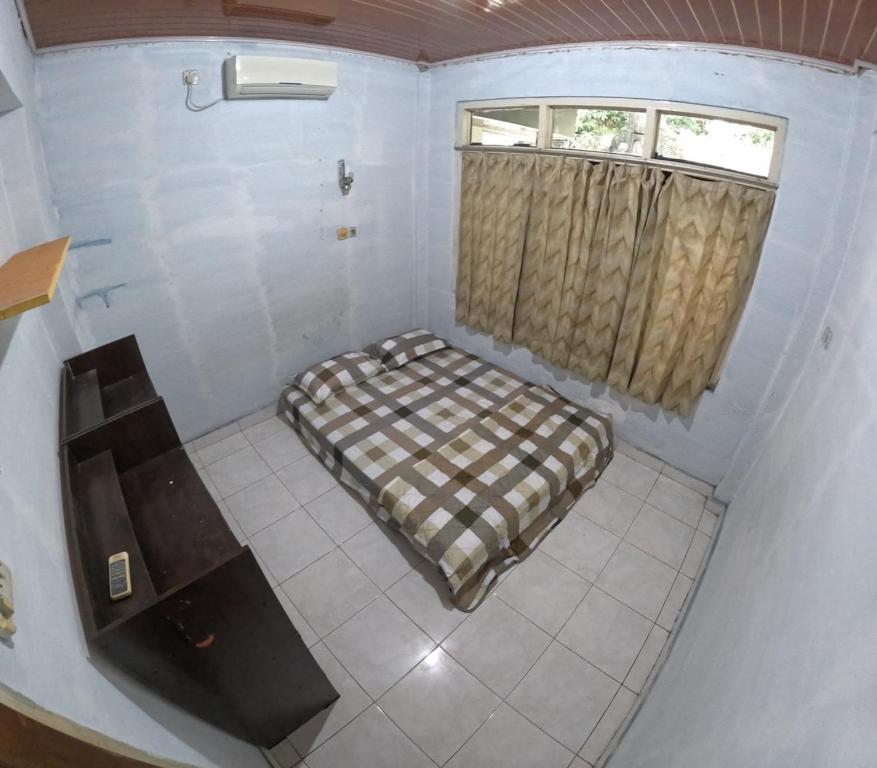 a small room with a bed and a window at Fanda Homestay Malioboro in Sentool