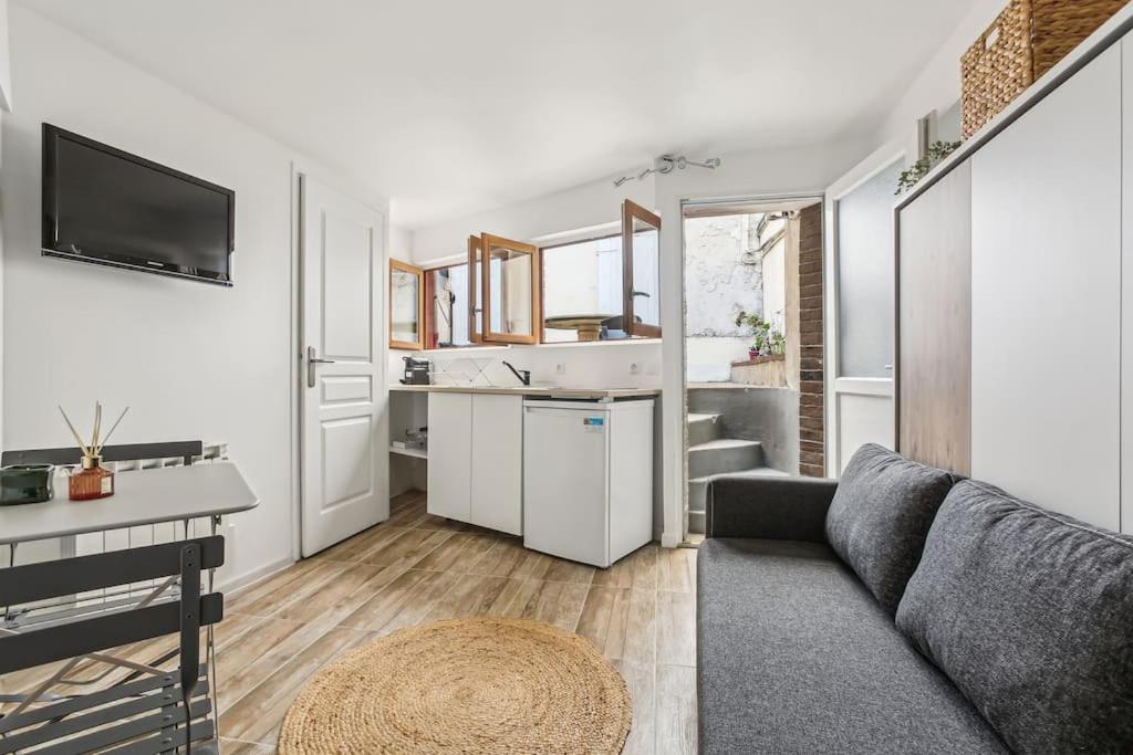 un salon avec un canapé et une cuisine dans l'établissement Studio with Little Garden-Terrace at Trocadero, à Paris