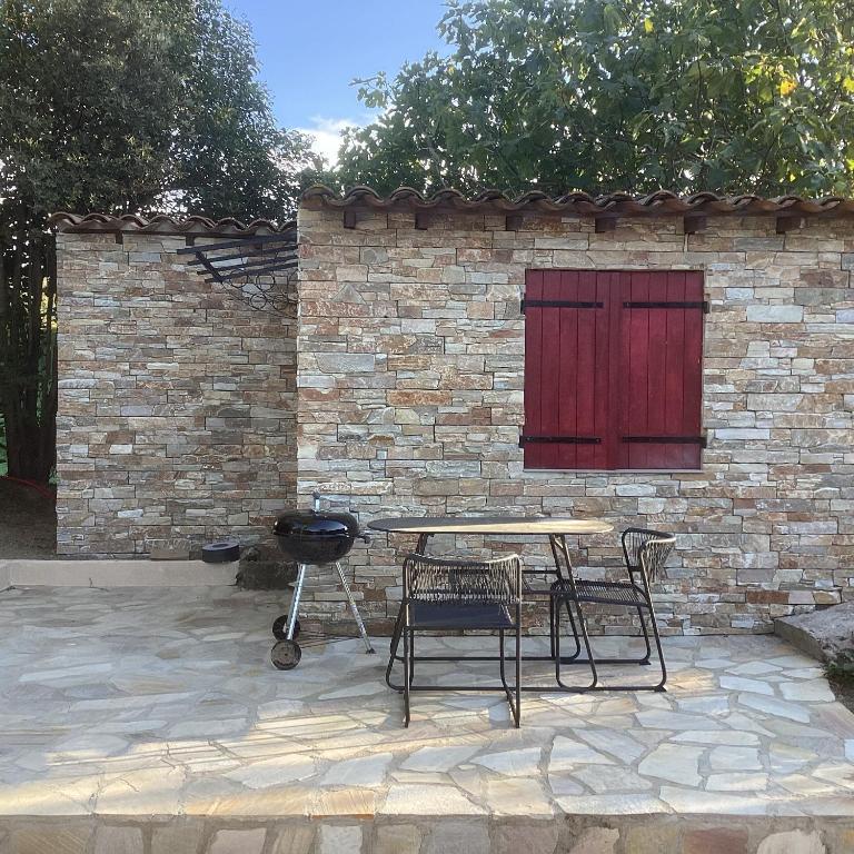 une table de pique-nique et des chaises devant un mur de briques dans l'établissement Bergerie, à Marseille