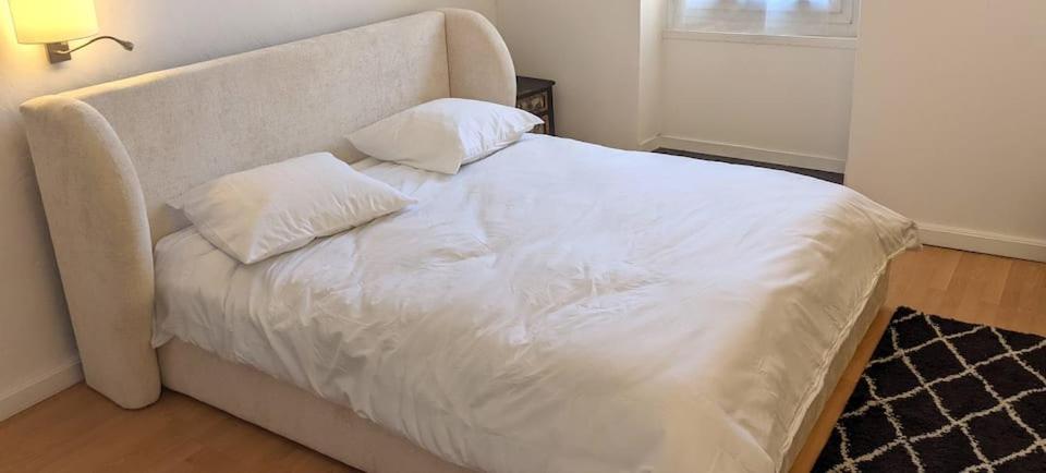 a white bed with two pillows on top of it at Chambre Voltaire ou Chambre Beckett, terrasse en bord de Sorgue in Le Thor