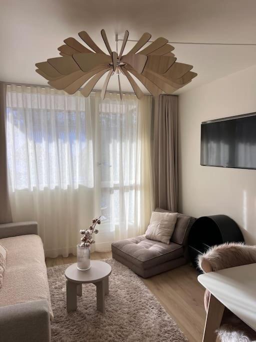 - un salon avec un canapé et un lustre dans l'établissement Baby Jane, Studio front de neige, à Isola