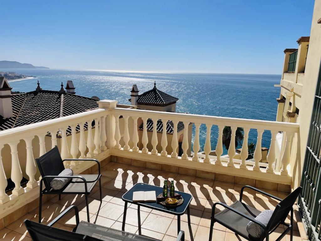 balkon z krzesłami i stołem i oceanem w obiekcie Apartamento Tamango Hill w mieście Nerja