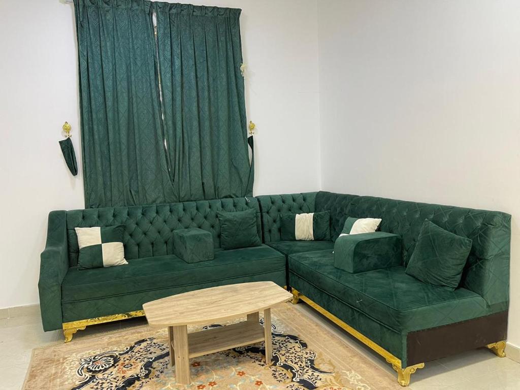 a green couch in a living room with a table at شقق عبدالله in AlUla