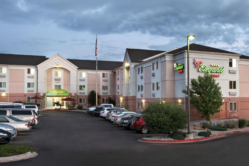 a hotel with cars parked in a parking lot at MCM Elegante Suites in Colorado Springs