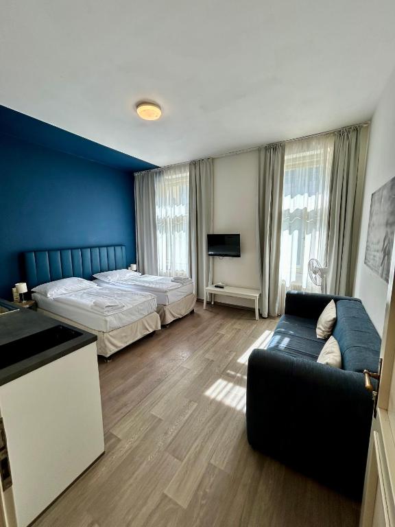 pokój hotelowy z łóżkiem i kanapą w obiekcie Alveo Suites w Pradze
