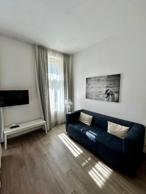 salon z niebieską kanapą i telewizorem w obiekcie Alveo Suites w Pradze
