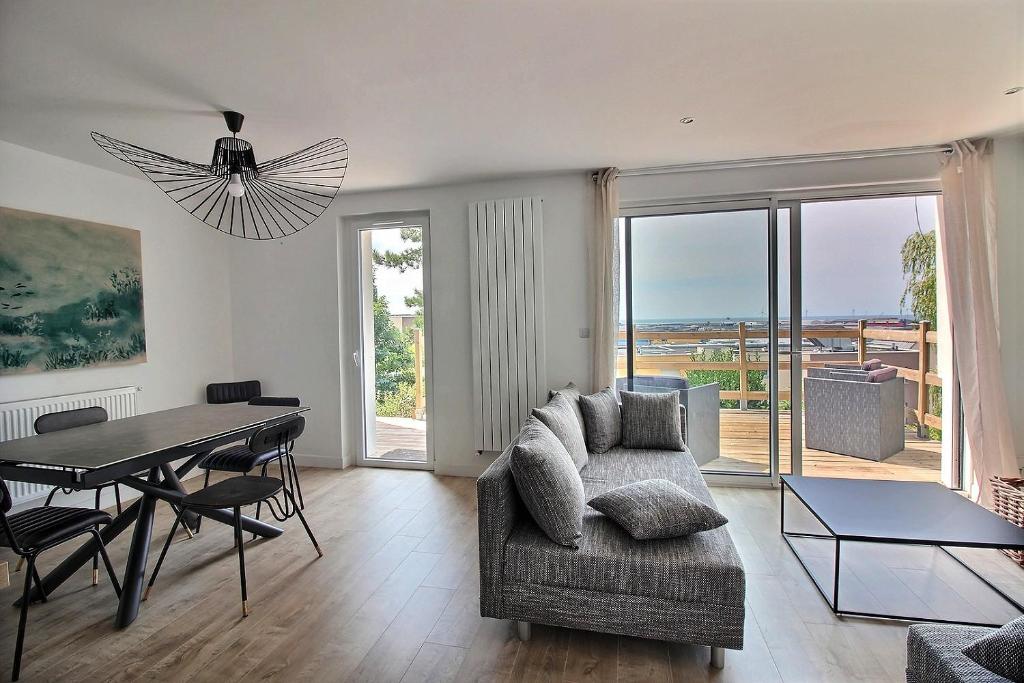 a living room with a table and a couch and a dining room at Maison de Vacances avec Vue sur mer - NAUSICAA in Boulogne-sur-Mer