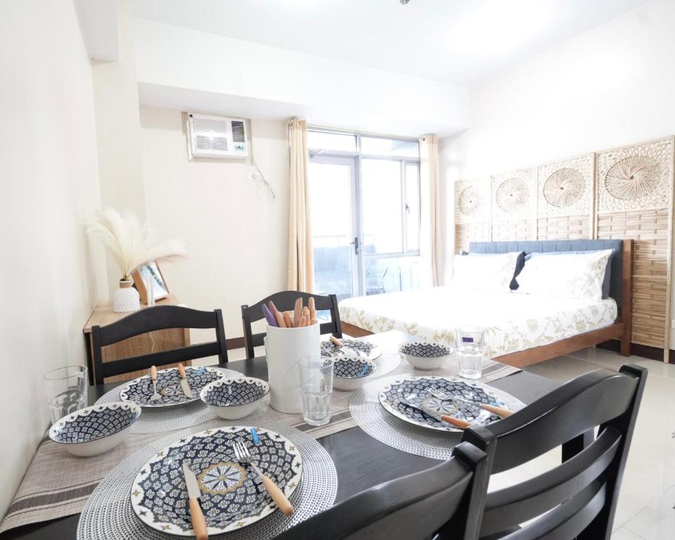 a dining room table with blue and white dishes on it at Cubao Manhattan Heights Residential Condo TC10N - Bright Studio with Pool, Balcony - Next to AliMall and SM - Walking Distance to Araneta Coliseum and Gateway Mall in Cubao Quezon City - Staycations by SMS in Manila