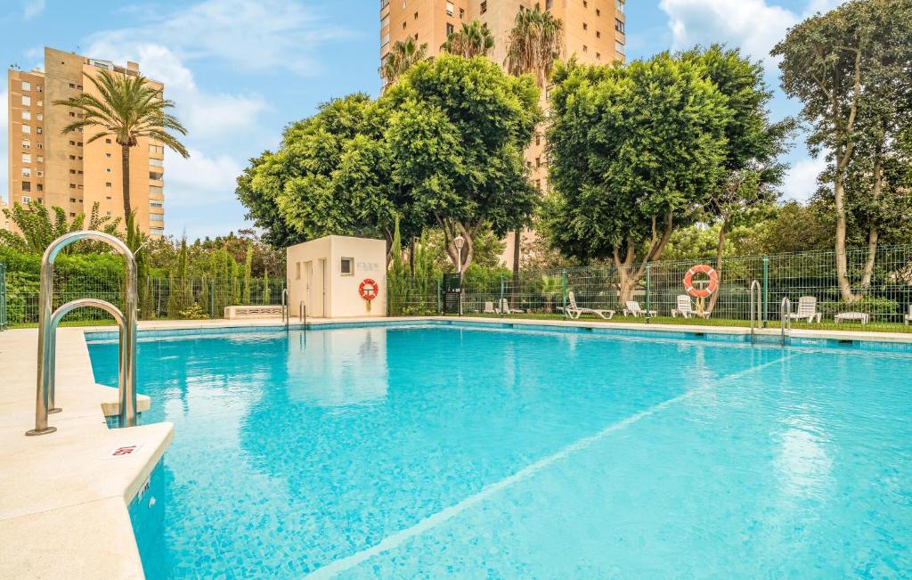 トレモリノスにあるCozy Apartment In Torremolinosの木々や建物のある青い大型スイミングプール