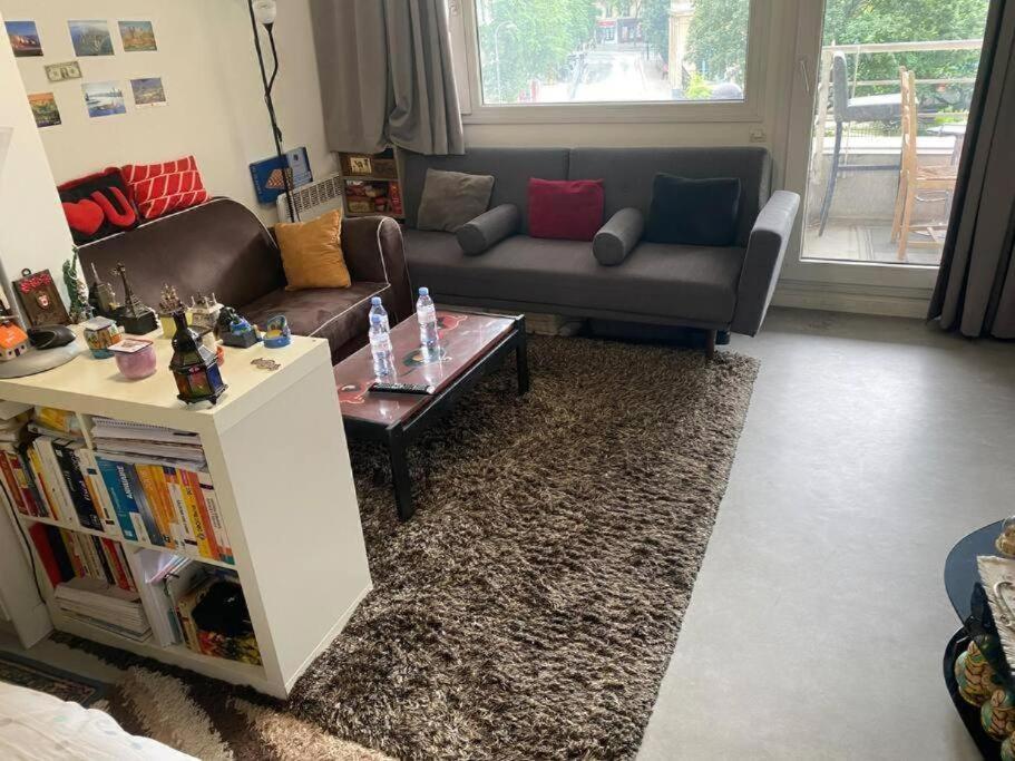 un salon avec un canapé et une table basse dans l'établissement Cosy appart à balcon Tour Eiffel et parking, à Paris