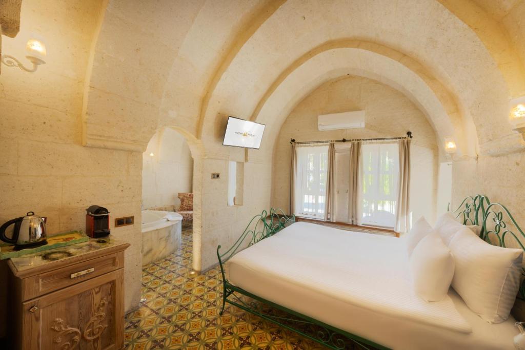 A bed or beds in a room at Tafoni Houses Cave Hotel