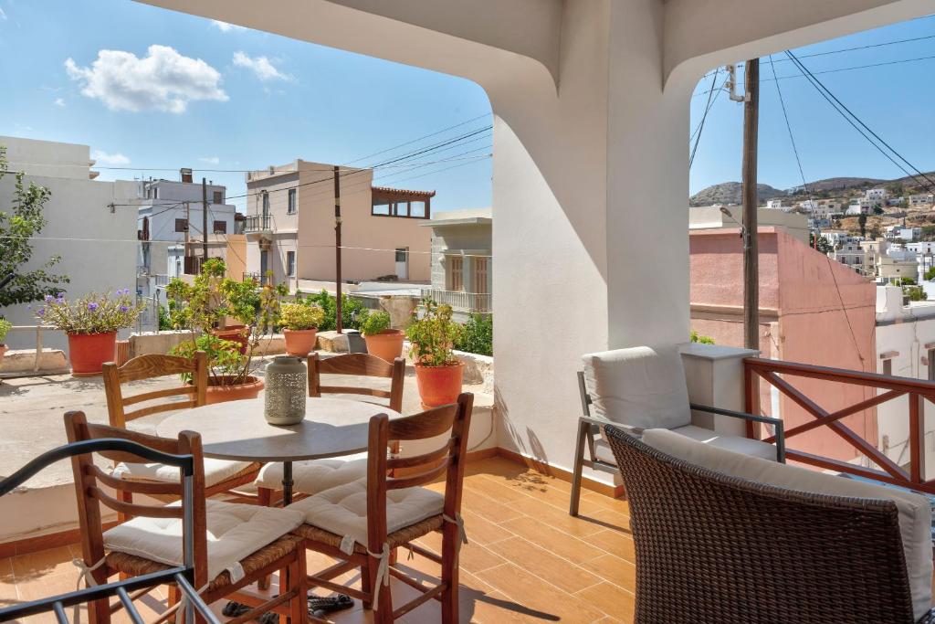 a patio with a table and chairs on a balcony at Voula Apartment in Ermoupoli