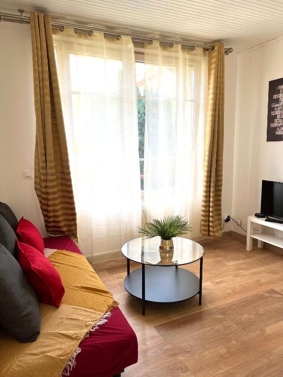 un salon avec un canapé et une table dans l'établissement Charmant logement situé en plein verdure et au centre ville de Rosny Sous Bois, à Rosny-sous-Bois