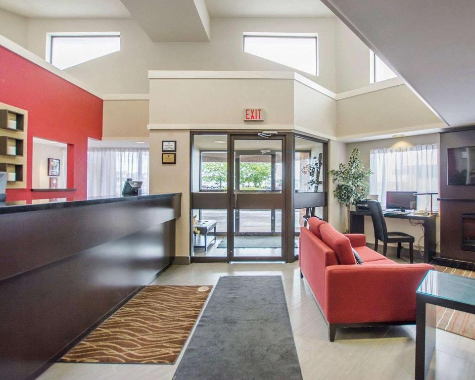 an office lobby with a red couch and a table at Comfort Inn in Amherst