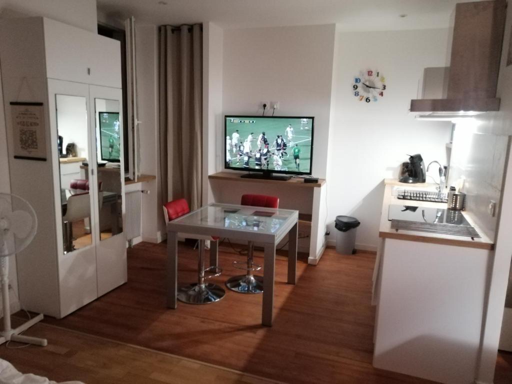 un salon avec une table et une télévision dans l'établissement Studio dans maison de ville, à Toulouse