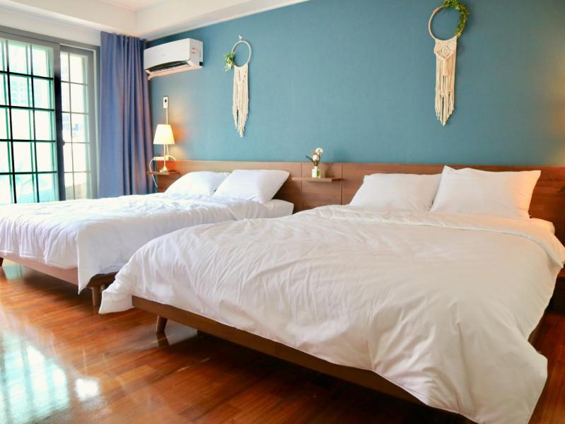 two beds in a bedroom with a blue wall at Family Pent House in Seoul