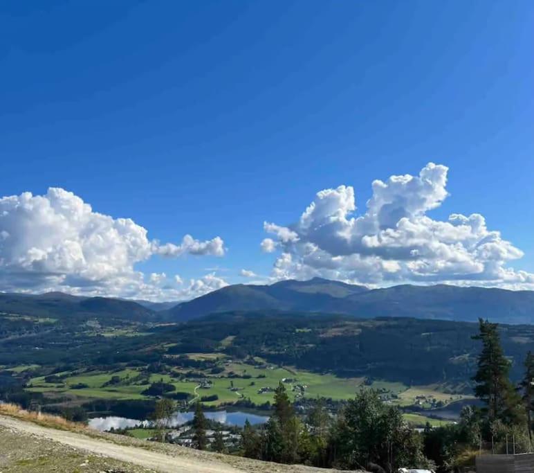 a view of a valley with mountains and a blue sky at Oppgradert leilighet i Tråstølen in Skulestadmo