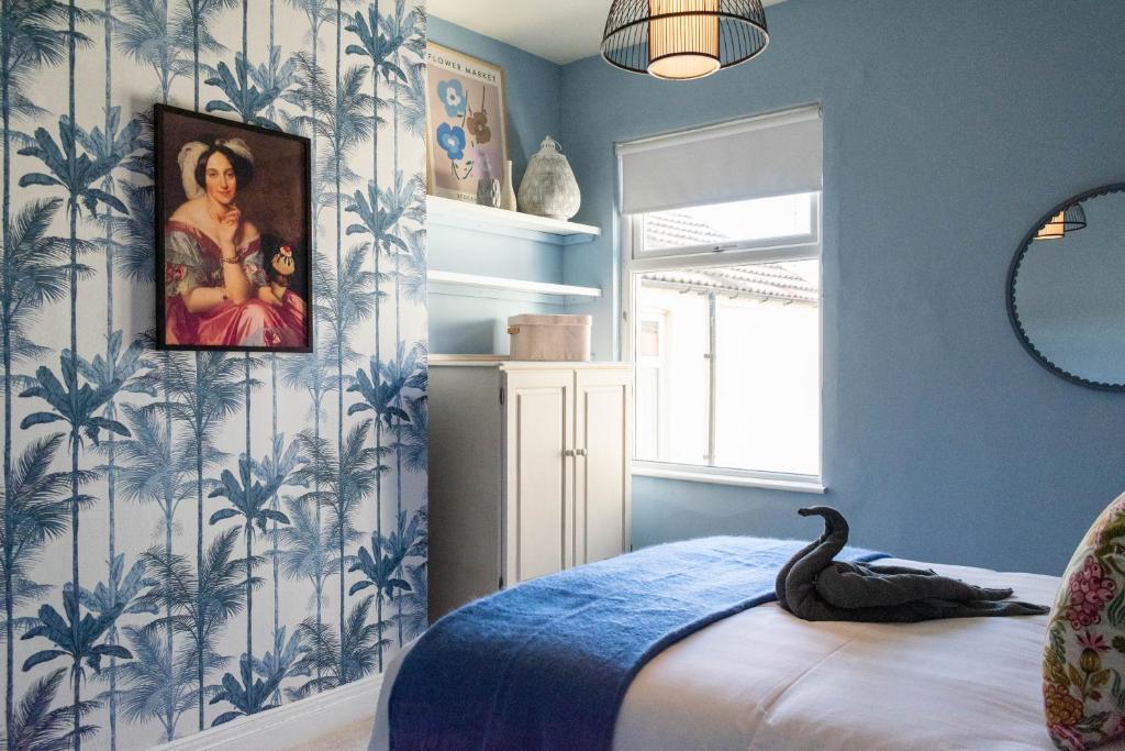 a bedroom with blue walls and a swan sitting on a bed at The Parade -Corner Plot Getaways in Redcar