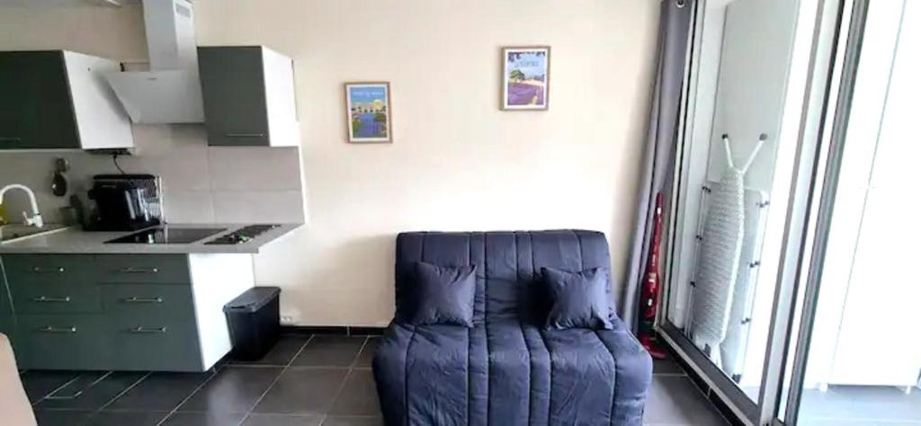 une cuisine équipée d'un fauteuil à poufs bleus dans l'établissement Studio cosy design au coeur de la ville, à La Grande Motte