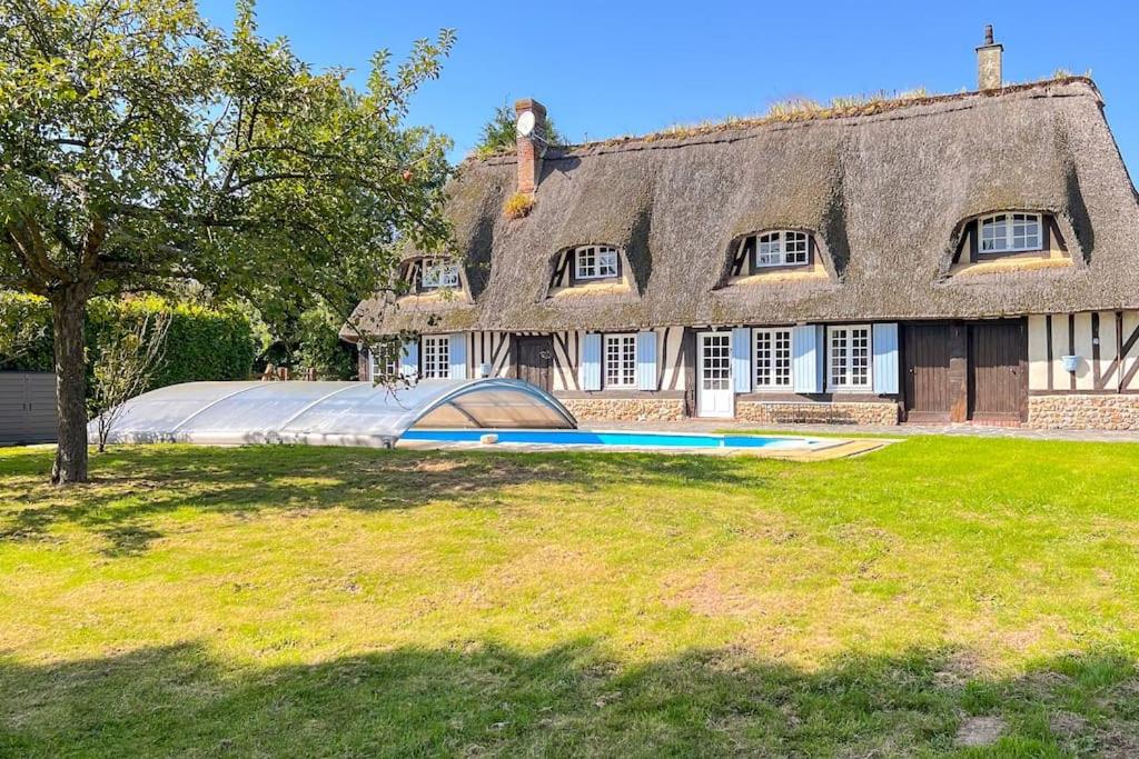une grande maison avec une grande piscine en face de celle-ci dans l'établissement Belle maison Normande 8pers avec piscine au calme, à Drucourt