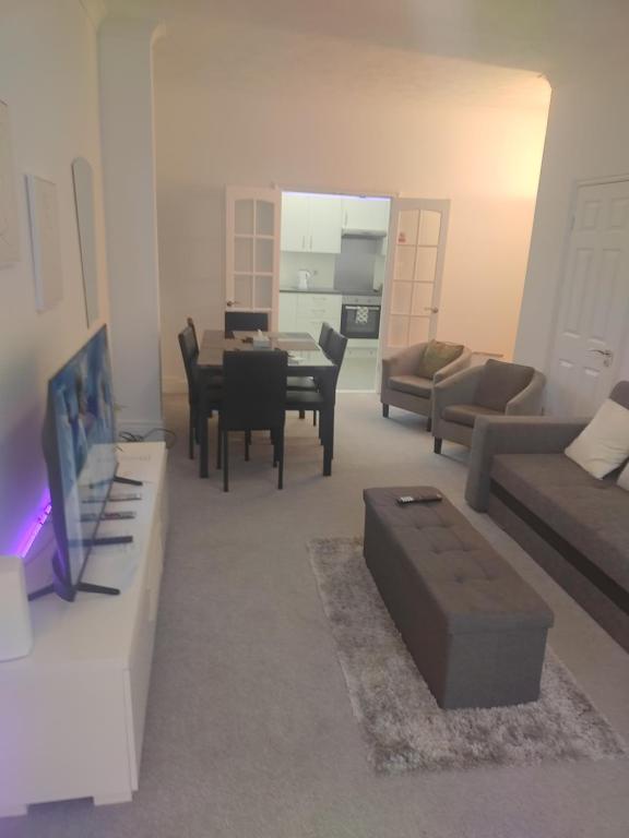 a living room with a couch and a dining room at Modern 2 bed house sleeps 6 in Portsmouth