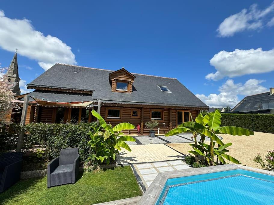 a house with a swimming pool in front of a house at Le Chalet aux Trésors ! in Notre-Dame-dʼAllençon