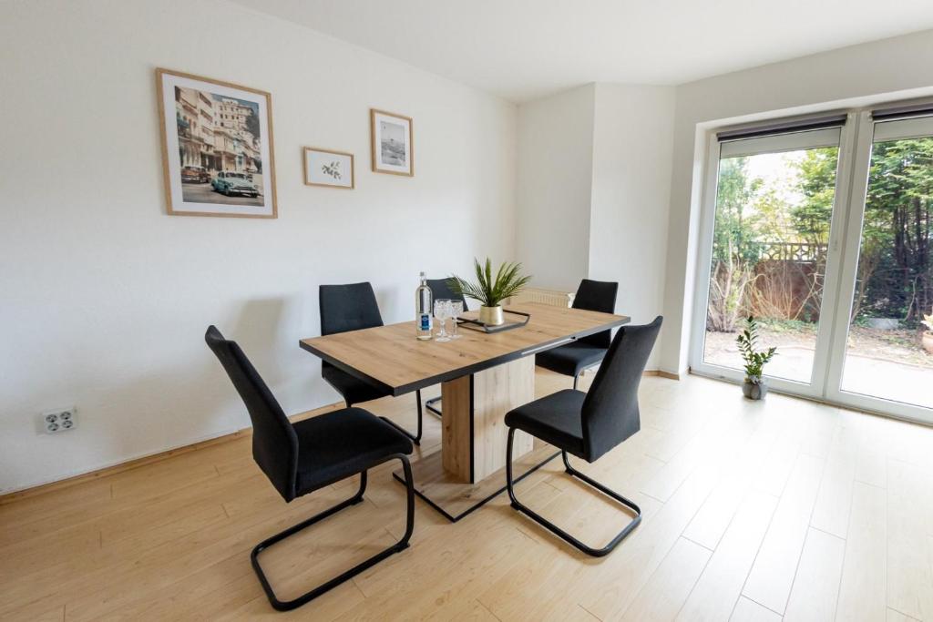 une salle à manger avec une table en bois et des chaises noires dans l'établissement Großzügiges Wohlfühlhaus zwischen Stadt & Meer, à Hinte