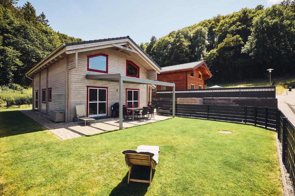 a small house with a yard with a lawn sidx sidx sidx at EifelGlückVII in Rieden