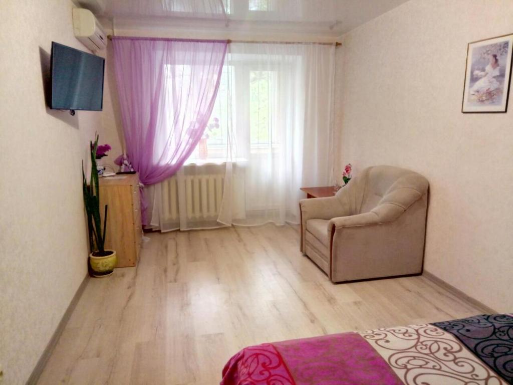 a living room with a chair and a window at Apartment - Generala Petrova Street in Odesa