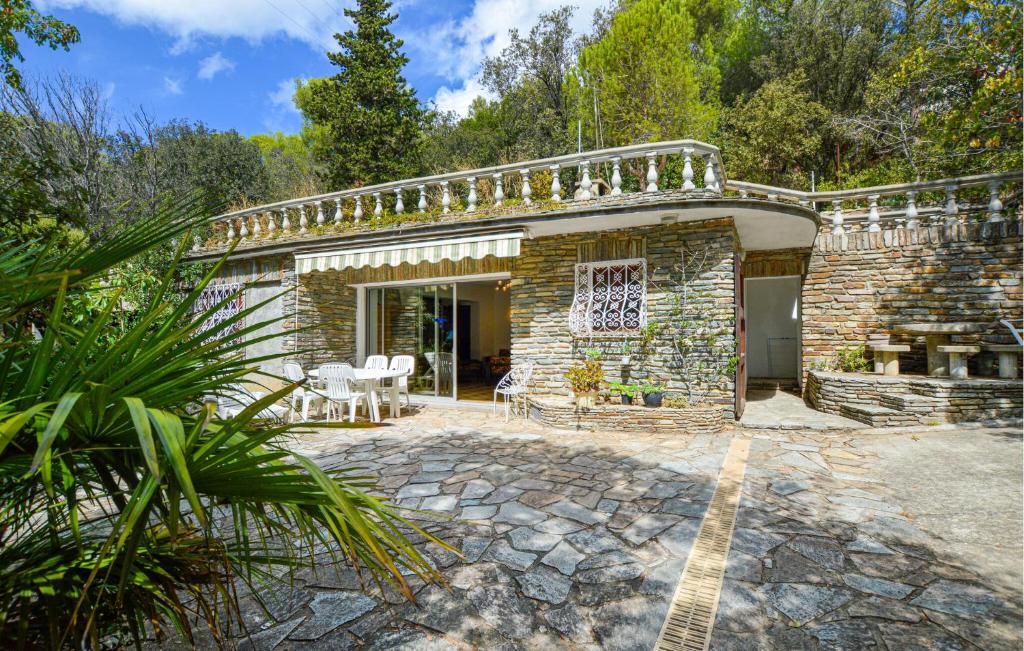 Cette maison en pierre dispose d'une terrasse avec une table. dans l'établissement 2 Bedroom Awesome Home In Farinole, à Farinole