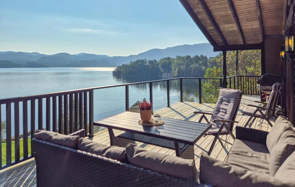 a balcony with a table and chairs and a view of the water at 5 Bedroom Cozy Home In Hebnes in Hebnes