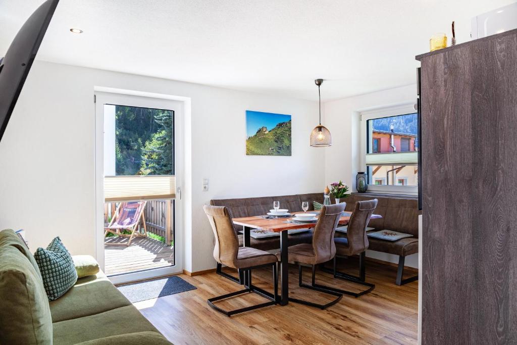 a dining room and living room with a table and chairs at Berghoamat Nauders in Nauders
