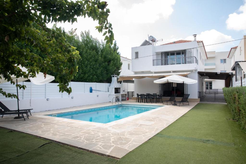 a villa with a swimming pool and a house at Koni Villa Paphos in Paphos City
