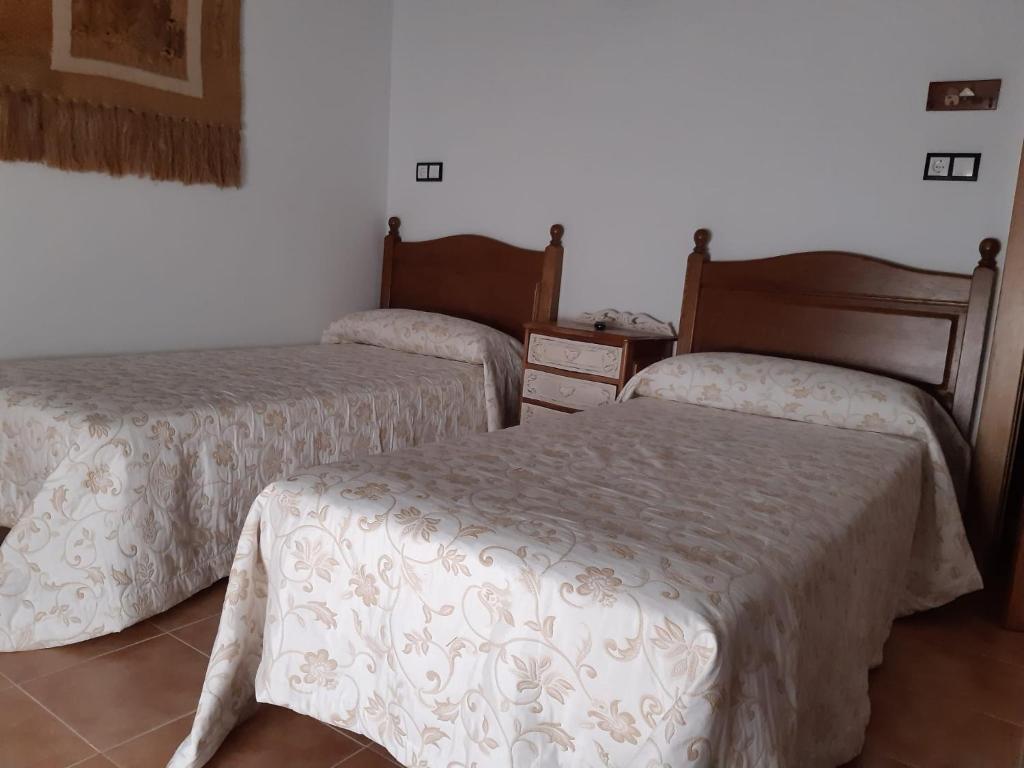 una habitación con dos camas y una mesa en Habitación Tomillar, en Lumpiaque