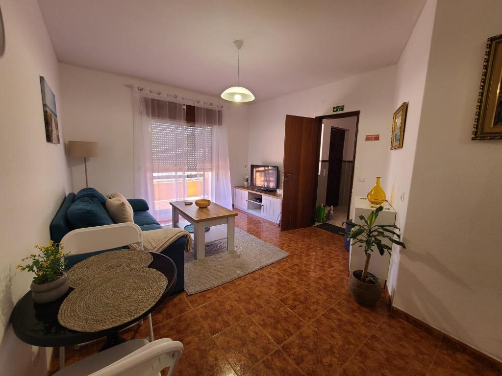 Una sala de estar con un sofá azul y una mesa. en Chez Marlene, en Lagos