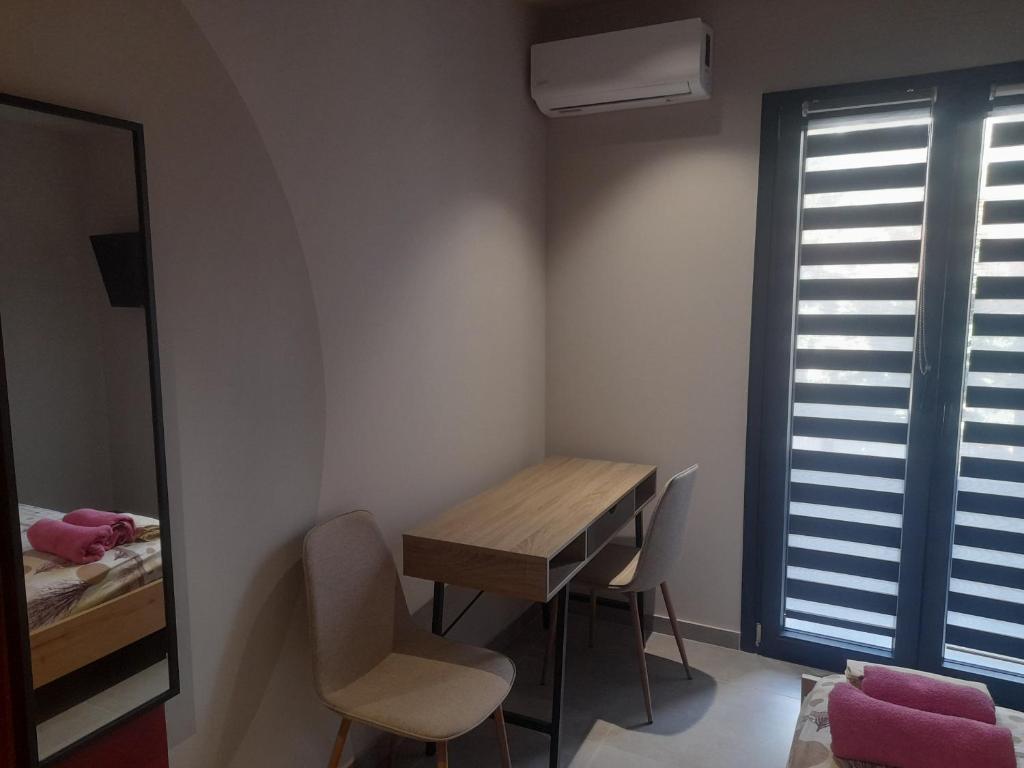a small room with a table and chairs and a mirror at Mp luxury houses Α3 in Larisa
